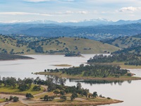 A drone view of New Hogan Lake in Calaveras County, included in the study area for the Calaveras River's watershed in DWR’s San Joaquin Basin Flood-MAR (Managed Aquifer Recharge) Watershed Studies, covering five San Joaquin tributaries: Calaveras, Stanislaus, Tuolumne, Merced, and Upper San Joaquin rivers. The Watershed Studies explore two Flood-MAR strategies and examine how changing flood patterns, water supply, and ecosystem health can be jointly managed through coordinated recharge and reservoir operations. Photo taken April 15, 2026.