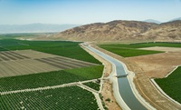 The aerial view looks southeast over the California Aqueduct and agricultural fields, near Highway 166, and the John R. Teerink Wheeler Ridge Pumping Plant in Kern County, California. Photo taken May 13, 2023.