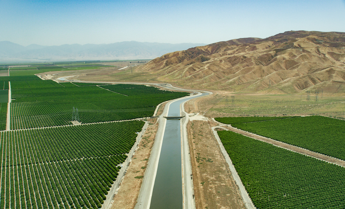 The aerial view looks southeast over the California Aqueduct and agricultural fields, near Highway 166, and the John R. Teerink Wheeler Ridge Pumping Plant in Kern County, California. Photo taken May 13, 2023.