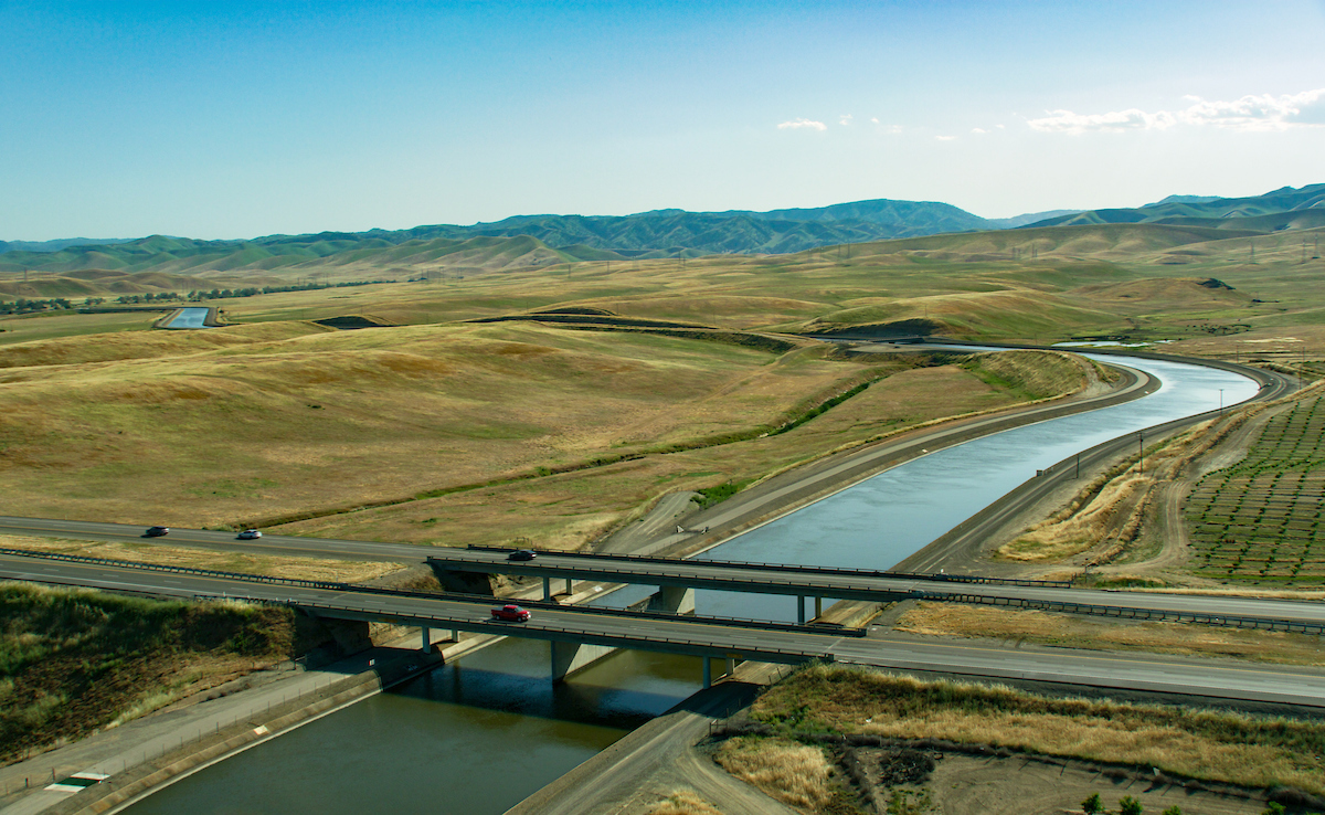 The aerial view looks southwest over the California Aqueduct and Interstate 5, near the Delta-Mendota Canal in Stanislaus County, California. The aqueduct is a critical part of the State Water Project that carries water from the Sacramento-San Joaquin Delta to the San Joaquin Valley and Southern California. Photo taken May 13, 2023.