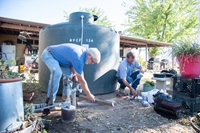Assistant installer Jeff Willis and Electrician Brian Callahan install a 1500 gallon potable water tank at a residence in Glenn County, California, where wells have run dry. The water hauling program which includes tank installations and water delivery is led by the North Valley Community Foundation. Photo taken August 10, 2022.