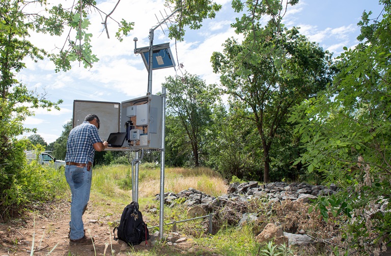 DWR water resources technician, fine-tunes technical equipment for a stream gage installed at Honcut Creek in Butte County. 