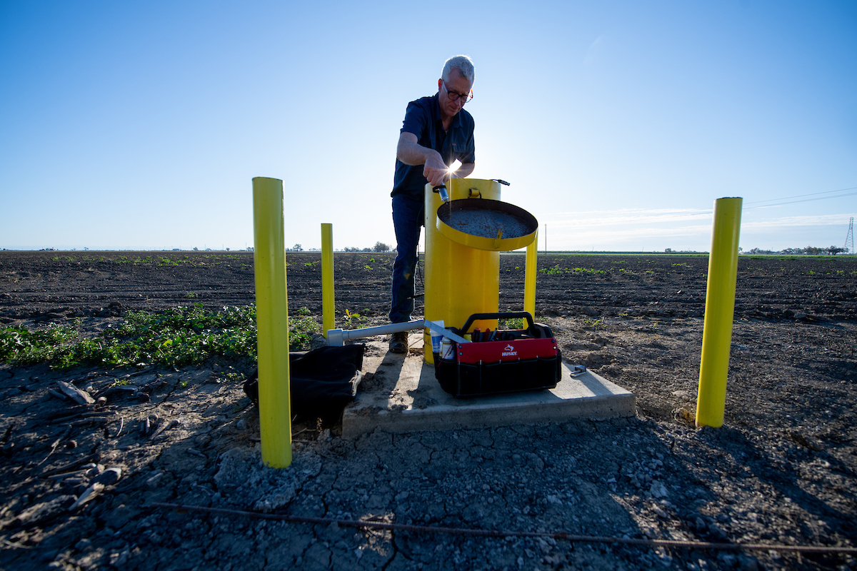 An engineering geologist with the California Department of Water Resources, measures groundwater levels at designated monitoring wells in Yolo County.