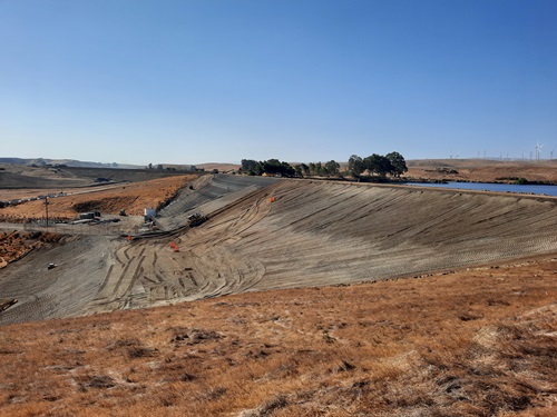Bethany Forebay Dam with restored downstream slope.  To protect the embankment from future rodent burrows, wire mesh and bedding rock is placed.