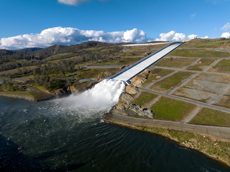 A drone provides an aerial view of the small cloud mist formed as water flows over the four energy dissipater blocks at the end of the Lake Oroville main spillway.
