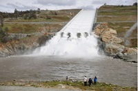Spectators watch as DWR begins the water release from 4,000 cubic feet per second (cfs) to 8,000 cfs from the Lake Oroville flood control gates down the main spillway and over the four energy dissipator blocks for the first time since April of 2019 in Butte County. Photo taken March 10, 2023.