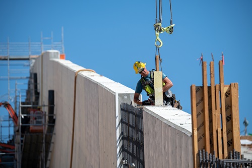 Workers prepare to remove a bulkhead from a wall panel with the help of a crane on the middle chute of the Lake Oroville main spillway