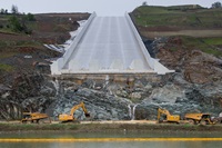 Excavators and haul trucks begin to remove a temporary road just below the new Lake Oroville main spillway. The road had been used during spillway construction. The California  Department of Water Resources ordered its removal to minimize water quality impacts with spillway use possible during the first week of April at the Butte County, California site.