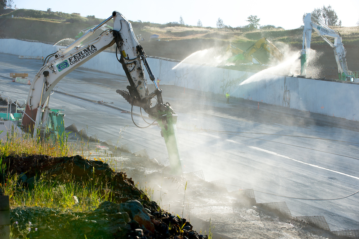 Crews begin removing temporary roller-compacted concrete sidewalls of the Lake Oroville main spillway