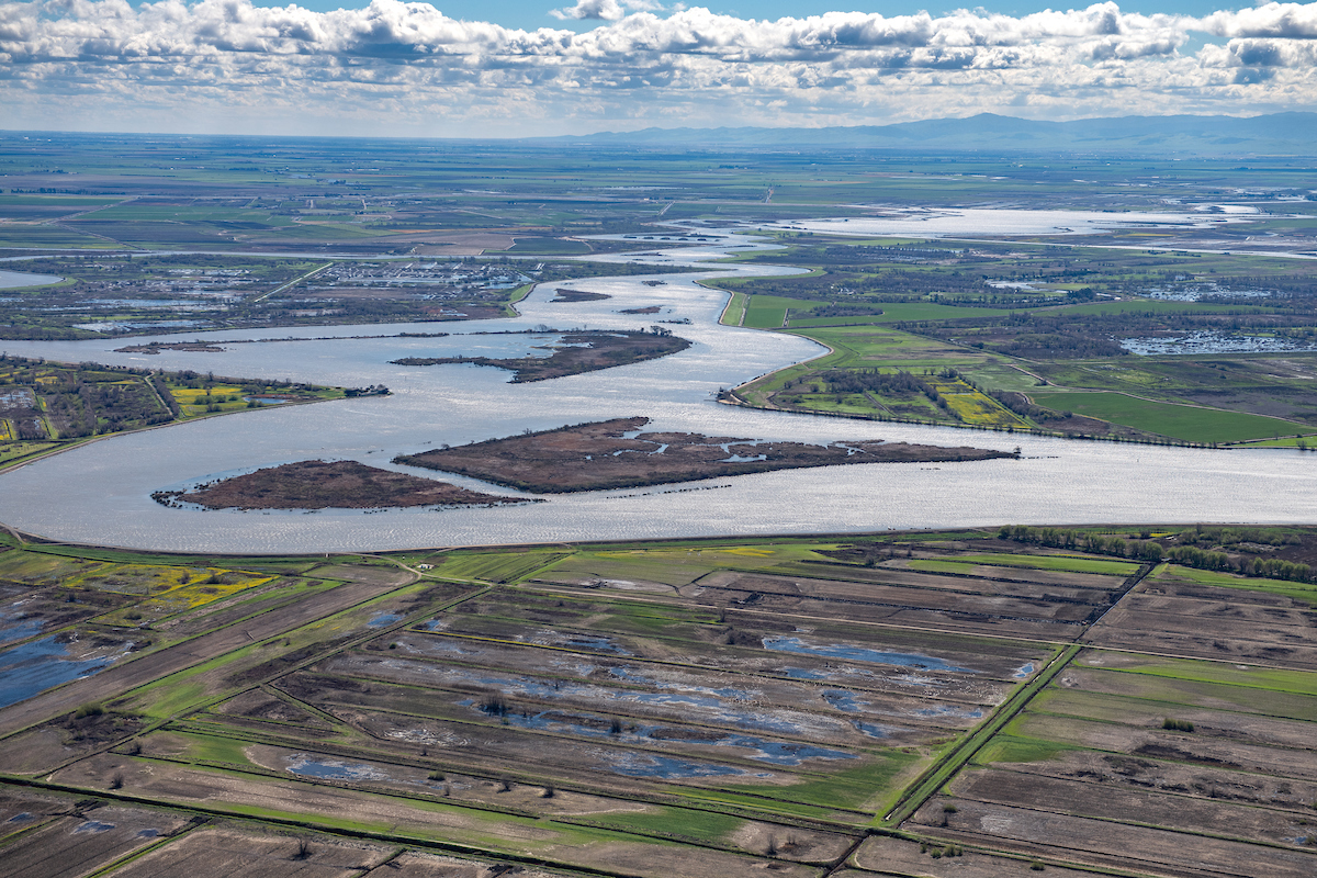 Aerial view looking east along San Joaquin River in the foreground is Mandeville Tip County Park, part of the Sacramento-San Joaquin River Delta in San Joaquin County, California.