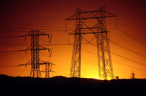 Sunset view of high-tension structures and power wires.