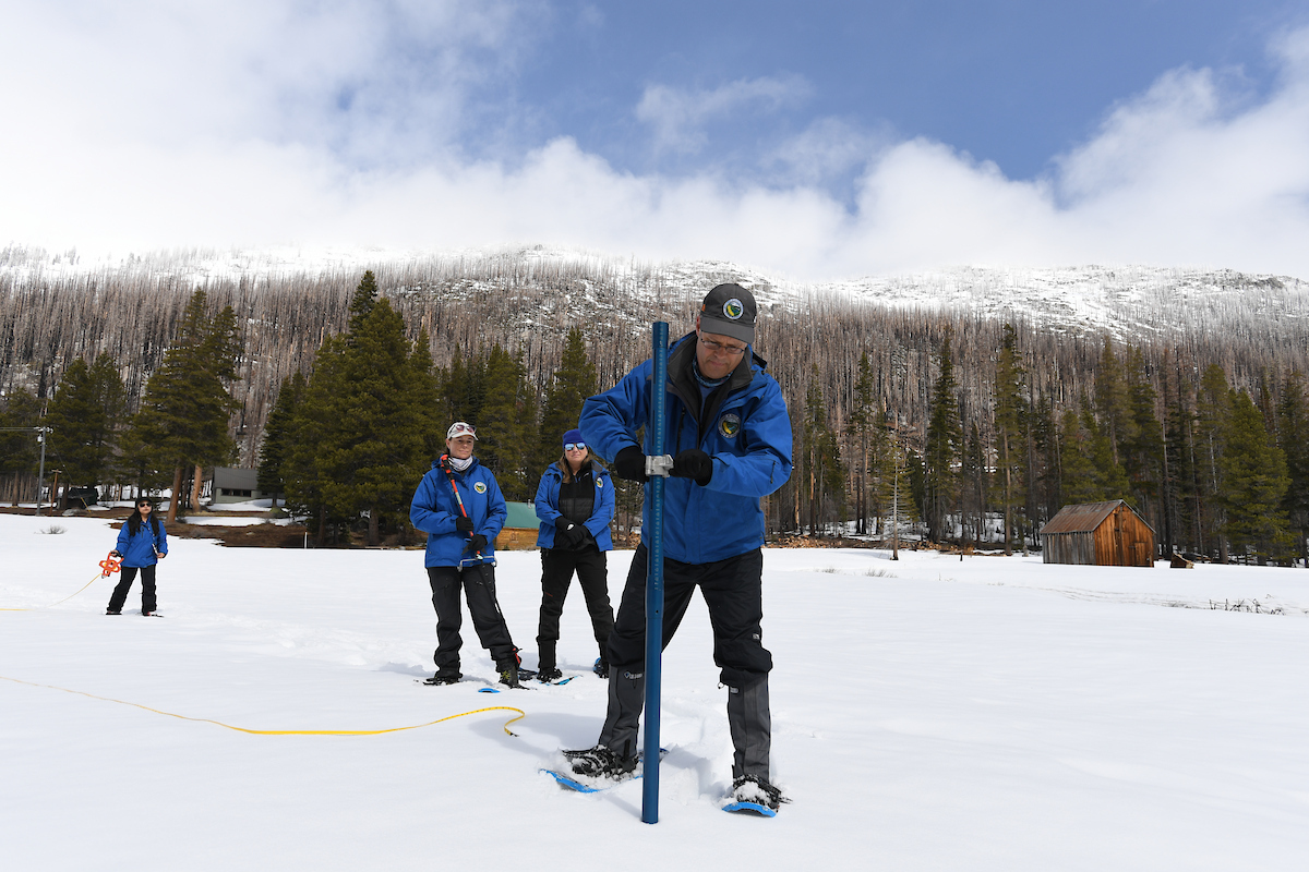 DWR employees measure snow at Philips Station during the fourth snow survey of the season. 