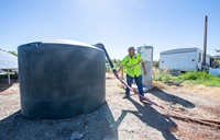 Water is delivered to fill a 1500 gallon potable water tank at a property in Glenn County, California, where wells have run dry. The water hauling program which includes tank installations and water delivery is led by the North Valley Community Foundation.
