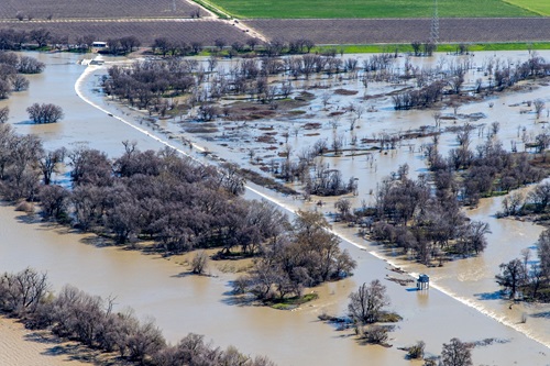 The Fremont Weir Adult Fish Passage control tower stands above water overtopping the Fremont Weir and entering the Yolo Bypass.  Taken February 27, 2024.