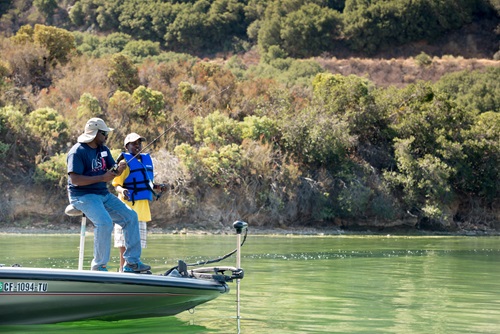 A volunteer introduces a young boy to fishing at Silverwood Lake at a C.A.S.T. event on September 13, 2014. ©DWR/2014